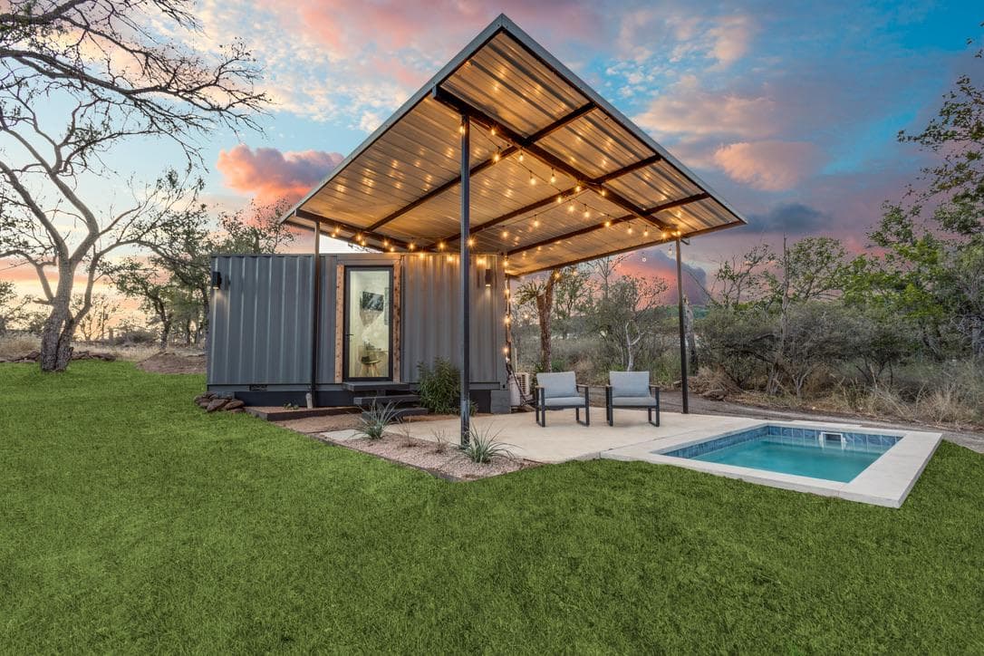Honeymoon Cottage exterior at dusk with private plunge pool and string lights beneath a cantilevered patio roof