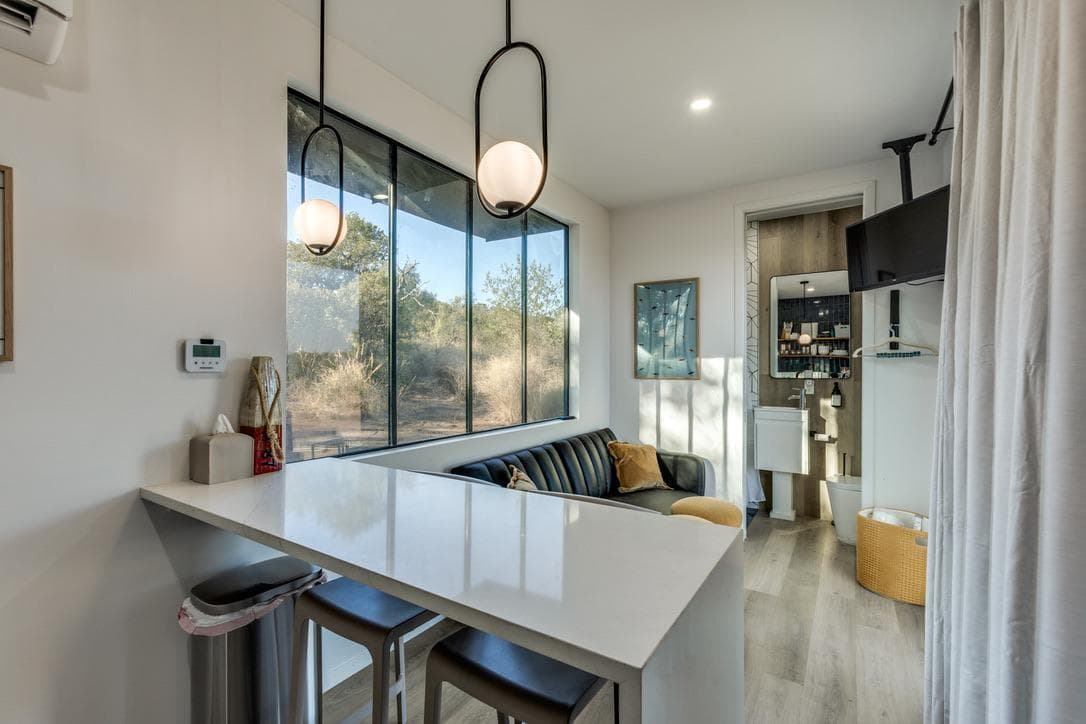 Bridal Suite Retreat interior, bright and spacious with a breakfast bar, pendant lighting, and floor-to-ceiling windows onto the Hill Country