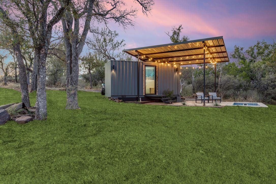 Garden Cottage tucked beneath live oak trees at dusk, quiet and secluded with string lights lit